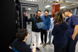 A photo of Nikos Vasilakis with students in a data center