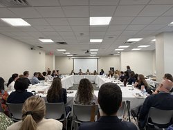 a photo of conference attendees and panelists gathered in a room