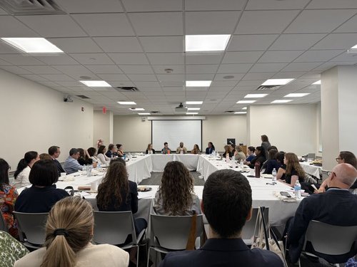 a photo of conference attendees and panelists gathered in a room