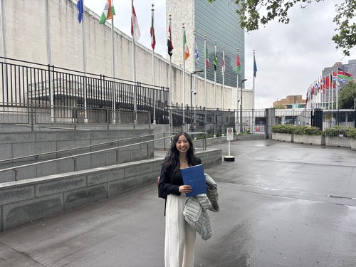 A photo of Ilana Nguyen standing in front of the United Nations building